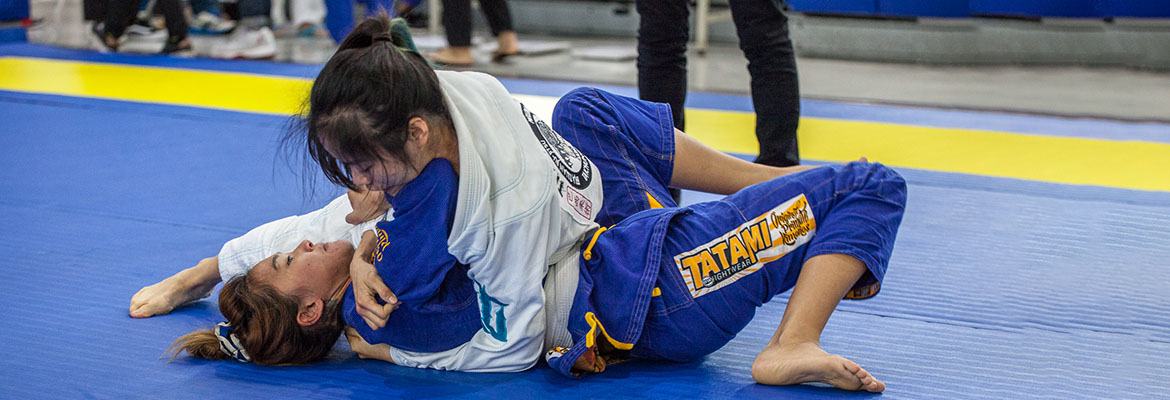 Two women engaged in a BJJ match